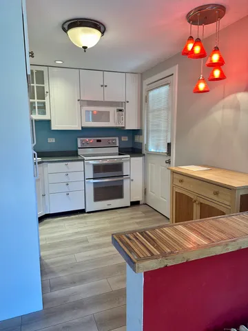 a kitchen with stainless steel appliances granite countertop a stove a refrigerator and a microwave