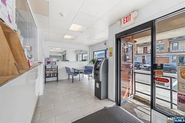 a living room with furniture and a refrigerator