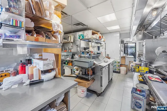a utility room with stainless steel appliances lots of clutter