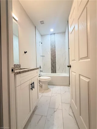 a bathroom with a tub sink vanity and a mirror