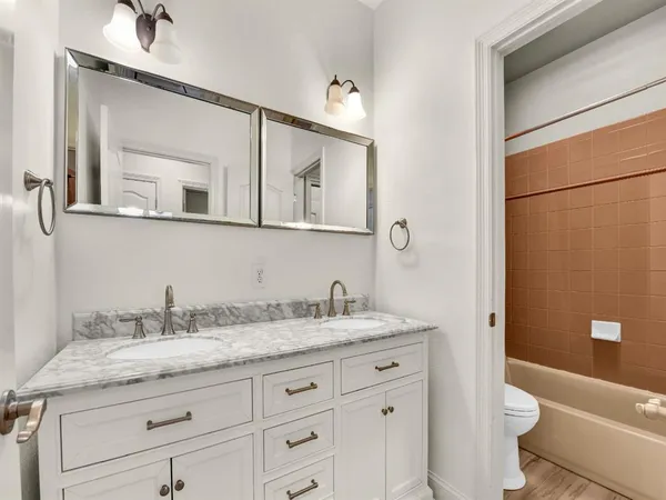 a bathroom with a granite countertop sink a toilet and a mirror