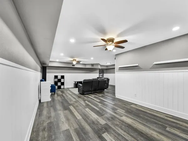 a view of a room with wooden floor and ceiling fan