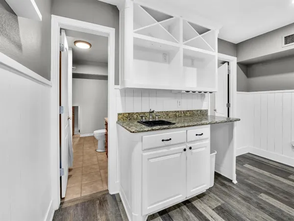 a kitchen with granite countertop white cabinets and white appliances