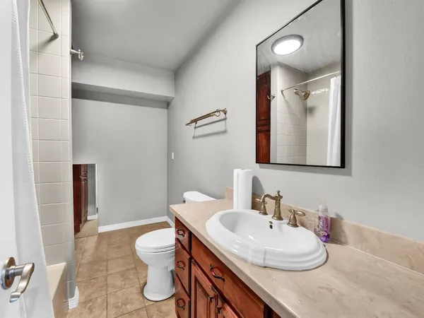a bathroom with a granite countertop sink toilet a mirror and shower