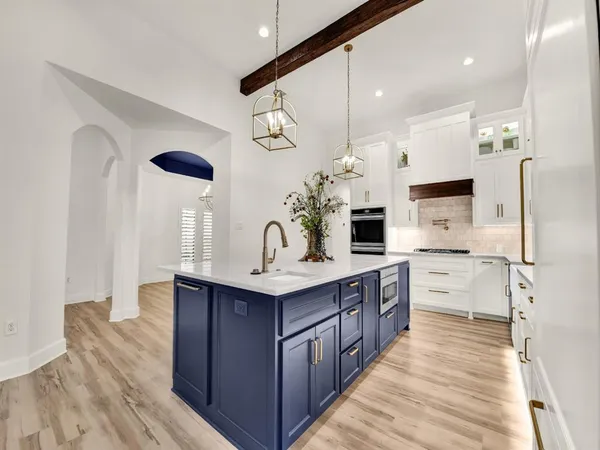 a large kitchen with a lot of counter space and wooden floor