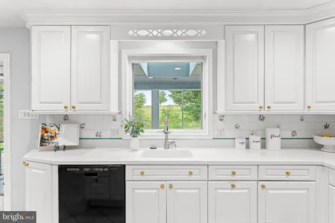 a kitchen with a sink window and stainless steel appliances