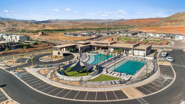 2123 Wolverine Way, Unit 2437 Washington, UT 84780 - Photo 9 of 40 Expansive community center featuring dual swimming pools, a shaded lounge area, and surrounding patio space with chaise seating