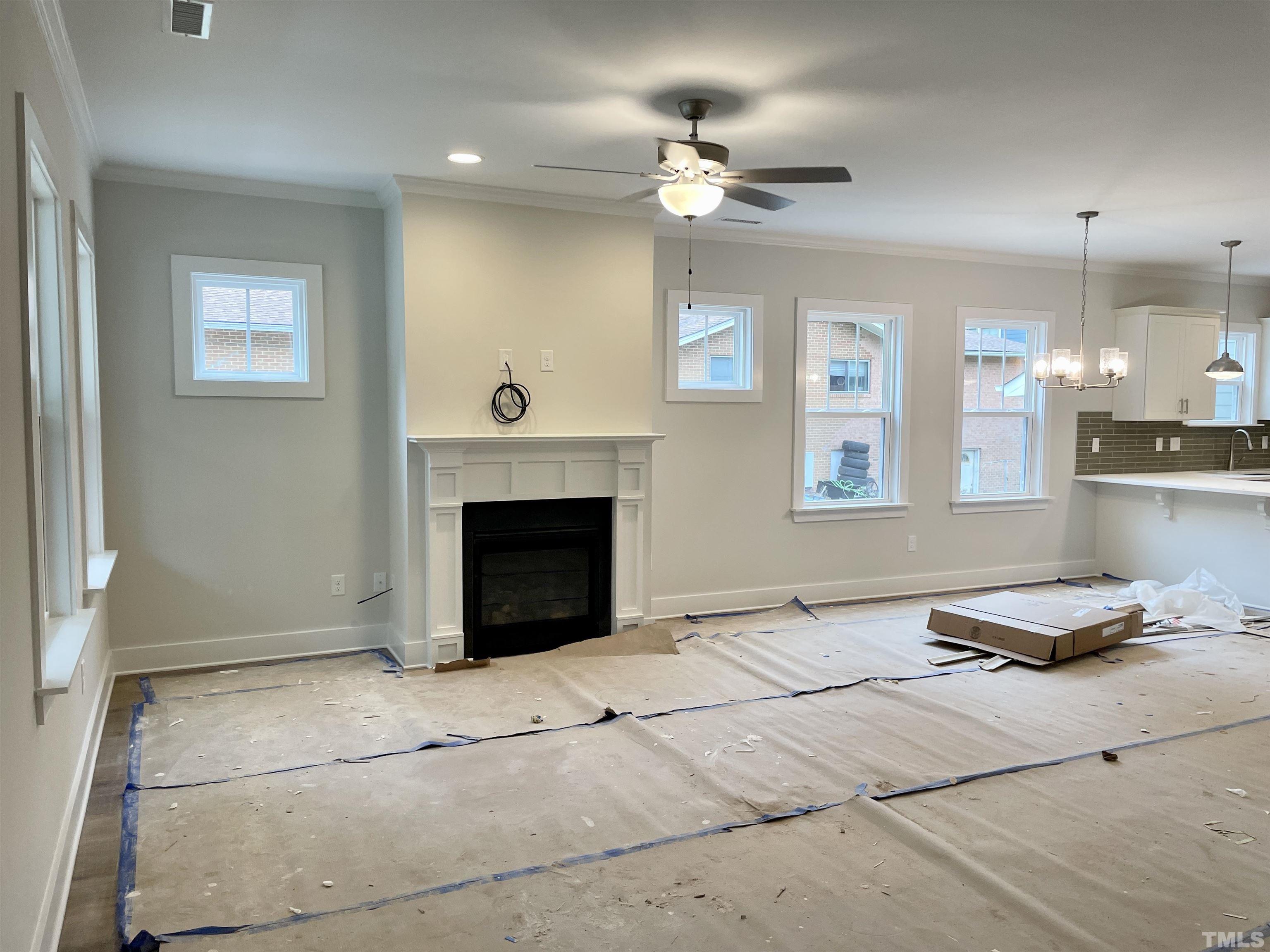 1308 B Castlebay Road Durham, NC 27704 - Photo 3 of 25 a living room with furniture a fireplace and a chandelier