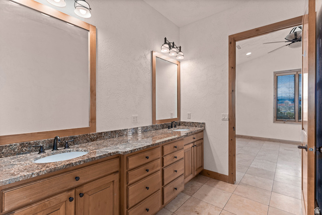 2464 East Granite Way St. George, UT 84790 - Photo 82 of 106 Full bath featuring double vanity, a ceiling fan, light tile patterned flooring, a textured wall, and vaulted ceiling