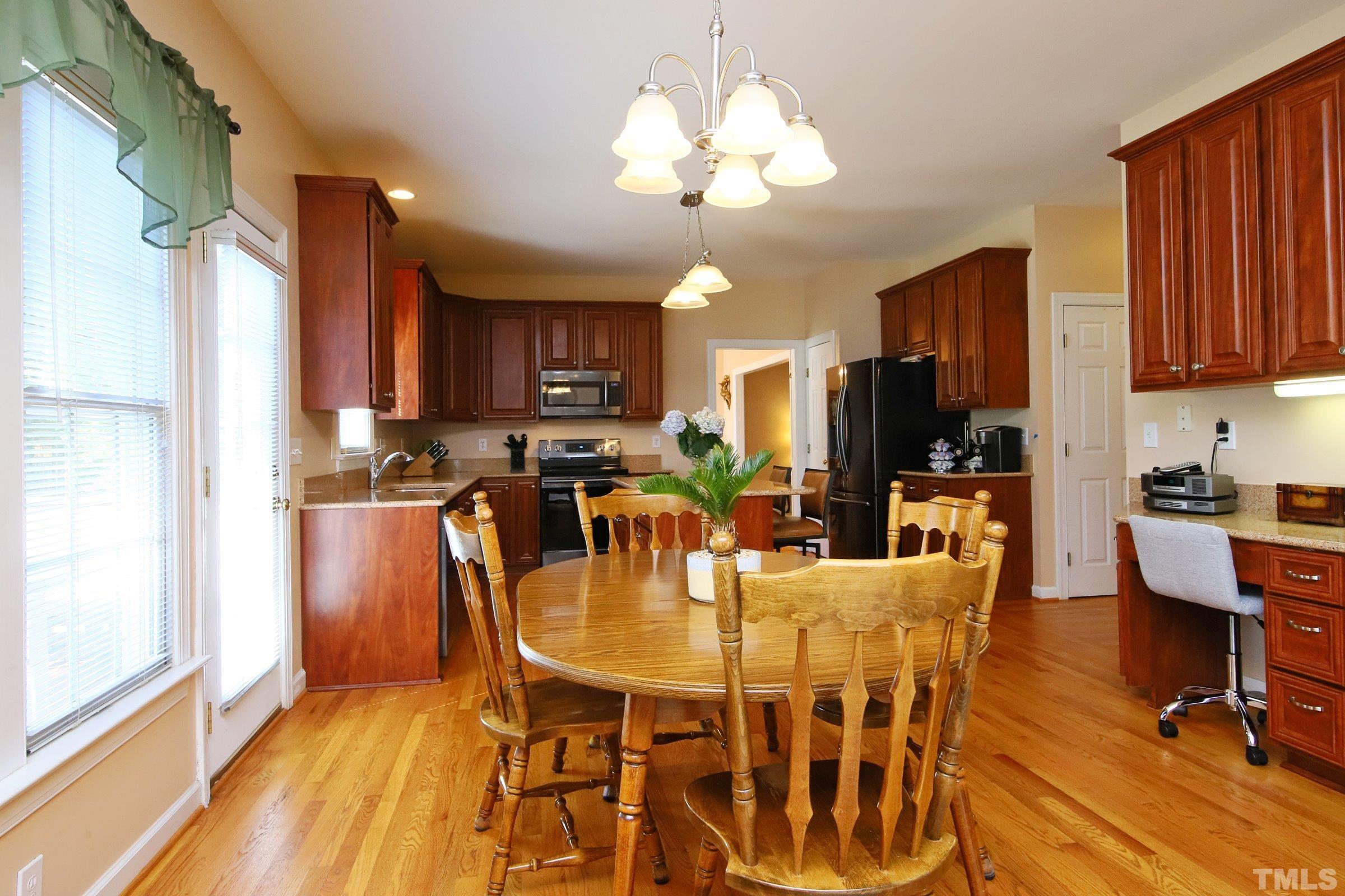 3307 Meadowrun Drive Durham, NC 27707 - Photo 17 of 29 a view of a dining room with furniture a kitchen and chandelier