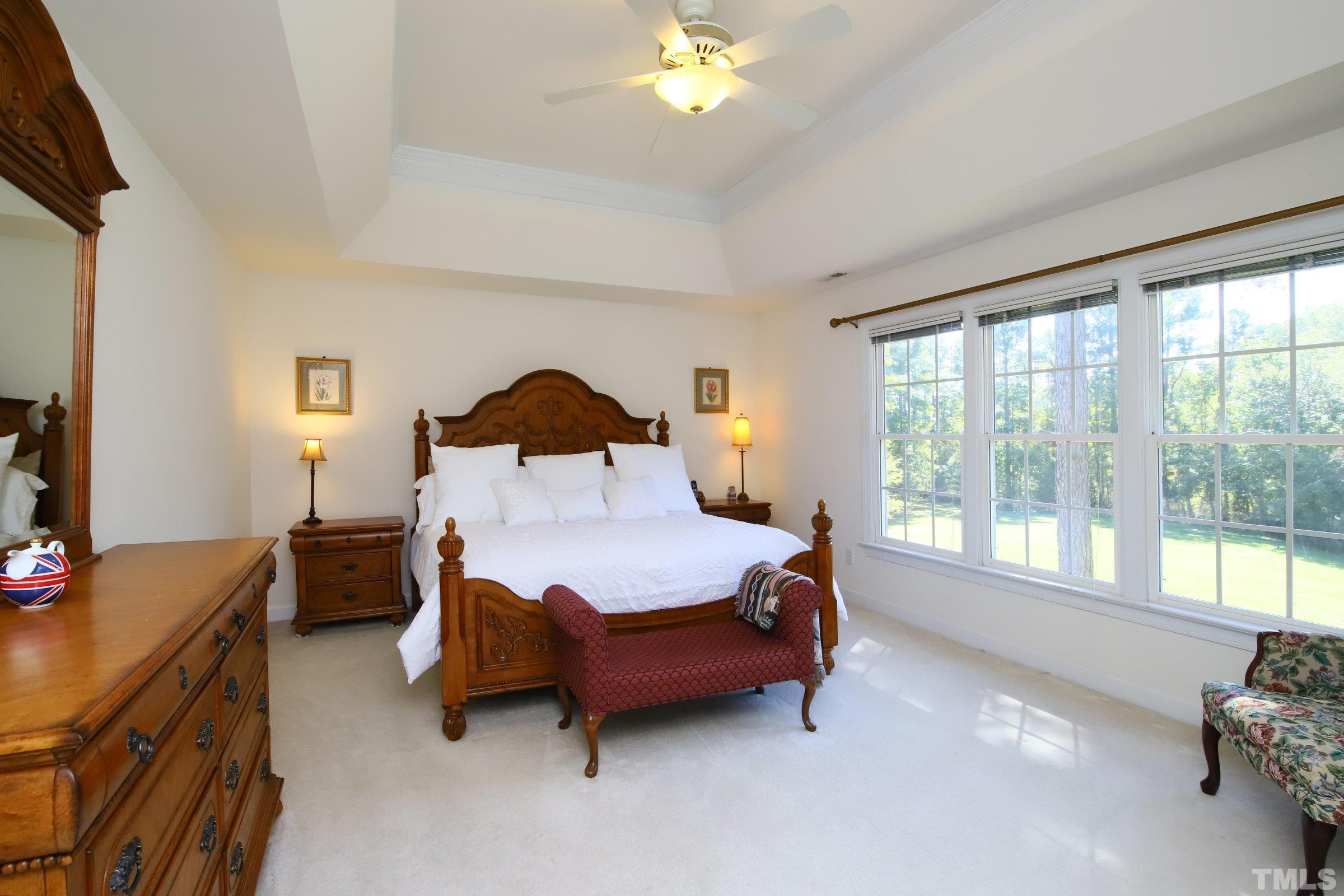 3307 Meadowrun Drive Durham, NC 27707 - Photo 23 of 29 a spacious bedroom with a bed and a chandelier