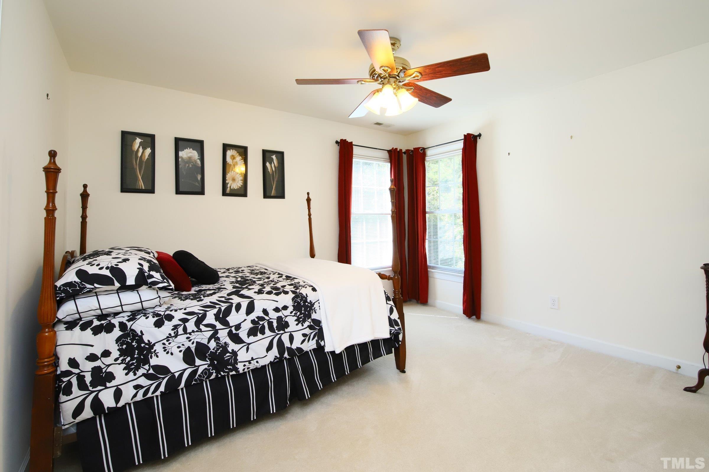 3307 Meadowrun Drive Durham, NC 27707 - Photo 28 of 29 a bedroom with a large bed and a chandelier