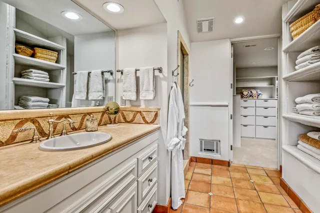 a bathroom with a tub a double vanity sink and mirror