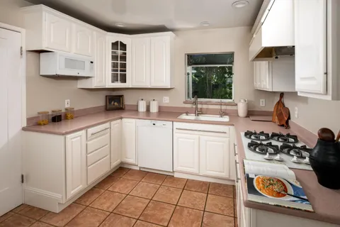 a kitchen with a sink a stove and cabinets