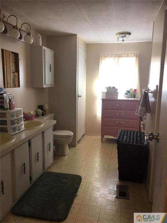 6 Poe Road, Unit 6 North Brunswick, NJ 08902 - Photo 14 of 22 a bathroom with a sink toilet and a mirror