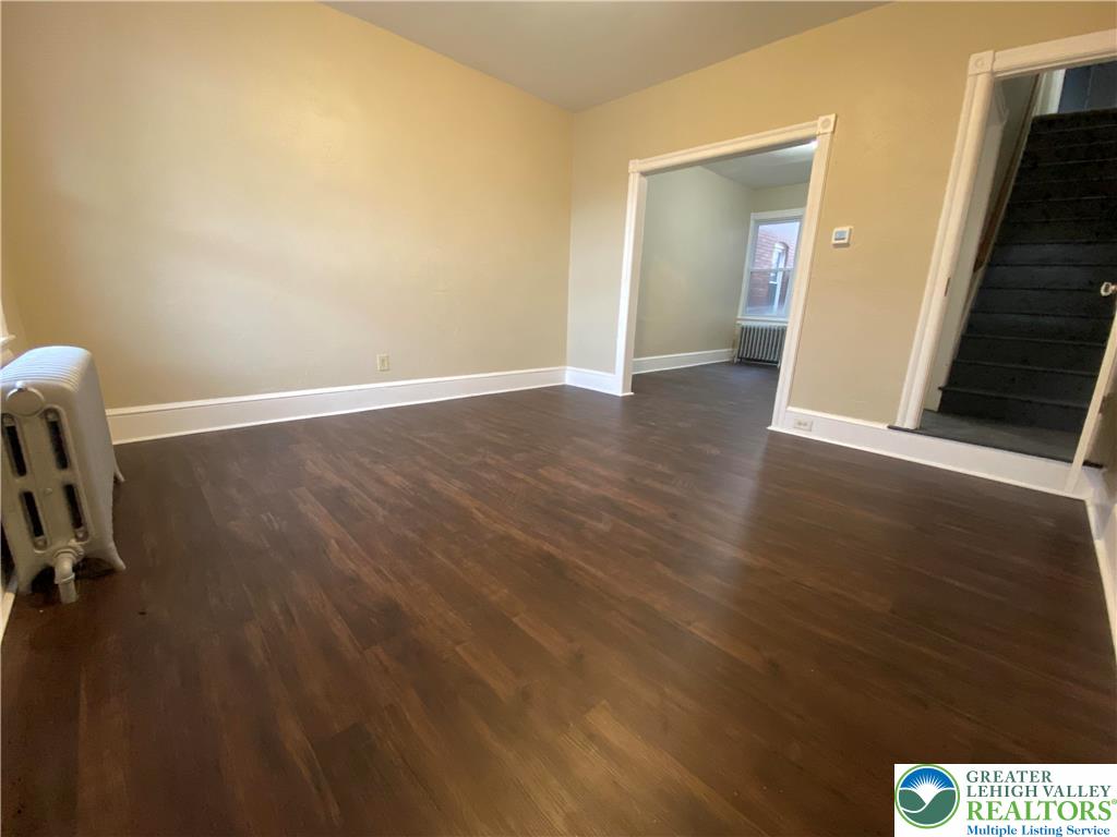 122 South Spruce Street Nazareth, PA 18064 - Photo 4 of 11 a view of an empty room with wooden floor and a fireplace