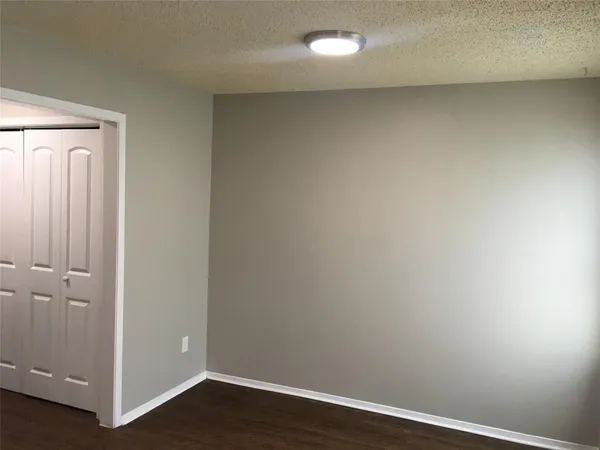 an empty room with wooden floor and closet