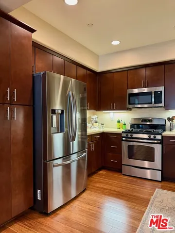 a kitchen with granite countertop a refrigerator stove and microwave