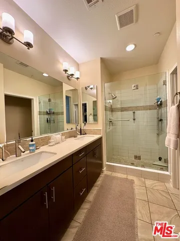 a spacious bathroom with a shower sink and mirror