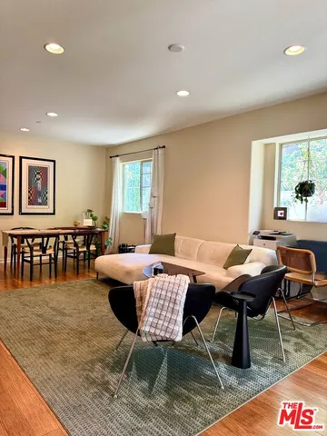 a living room with furniture a rug and a table