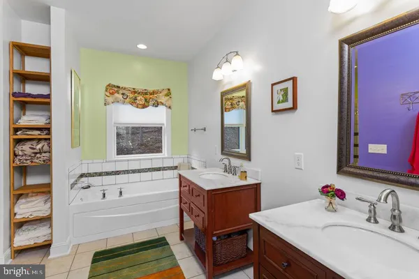 a bathroom with a tub sink and mirror