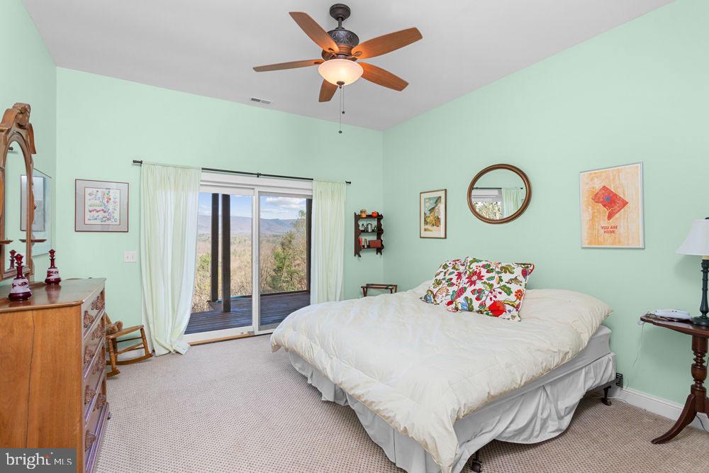 9586 Brunk Spring Lane Broadway, VA 22815 - Photo 38 of 57 a bedroom with a bed and a chandelier