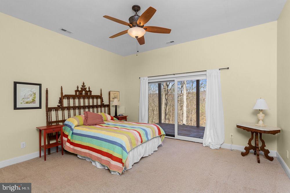 9586 Brunk Spring Lane Broadway, VA 22815 - Photo 39 of 57 a bedroom with a bed and a chandelier
