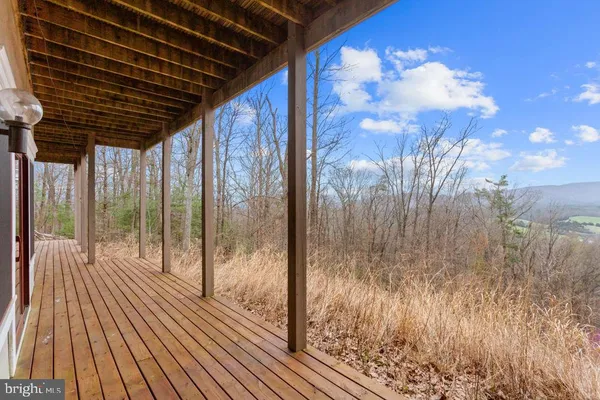 a front view of a house with wooden fence and a tree