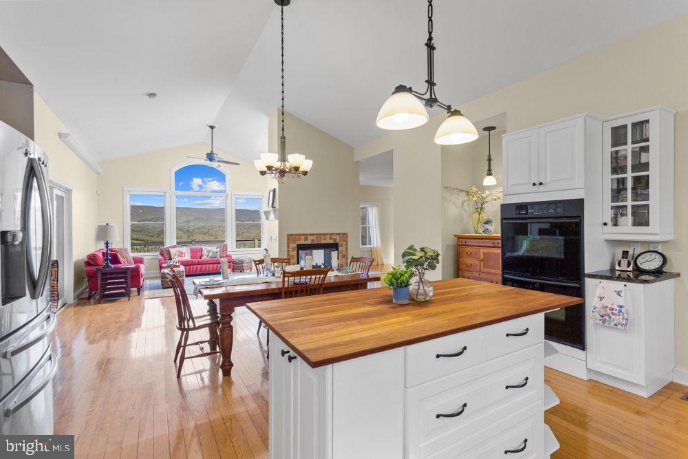 9586 Brunk Spring Lane Broadway, VA 22815 - Photo 56 of 57 an open kitchen with dining table and wooden floor