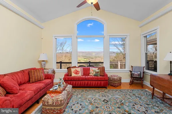 a view of a dining room and livingroom with furniture wooden floor a chandelier