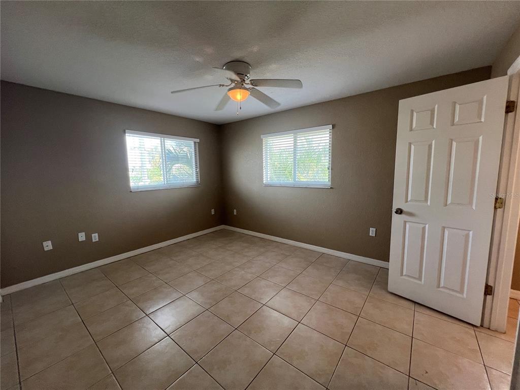 2704 2nd Street, Unit 16 Indian Rocks Beach, FL 33785 - Photo 11 of 23 an empty room with windows and fan