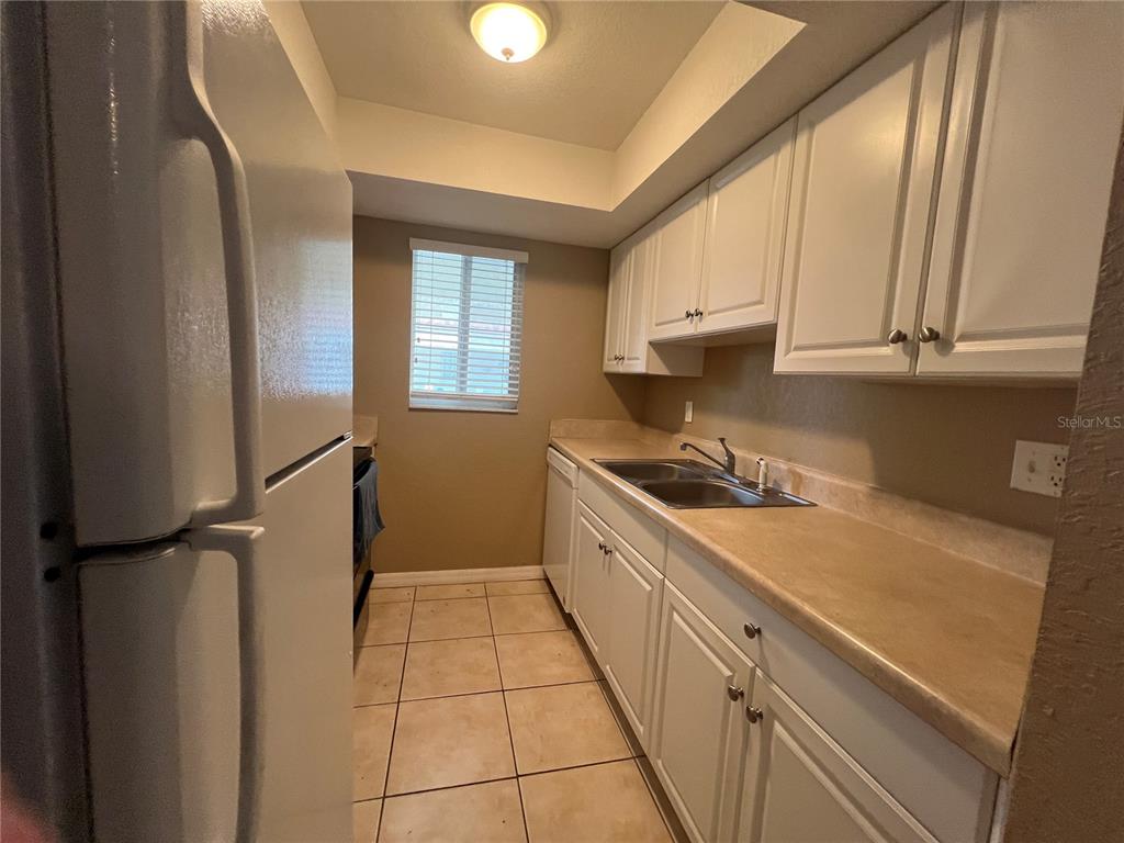 2704 2nd Street, Unit 16 Indian Rocks Beach, FL 33785 - Photo 15 of 23 a kitchen with a sink cabinets and a window