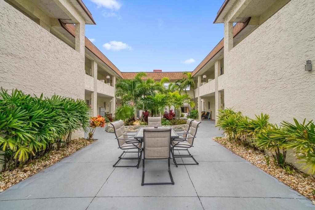 2704 2nd Street, Unit 16 Indian Rocks Beach, FL 33785 - Photo 3 of 23 a view of patio with a table and chairs and potted plants