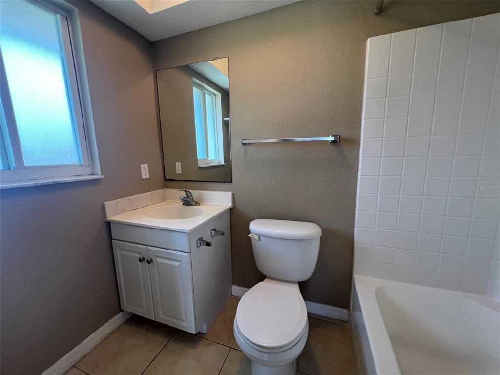 2704 2nd Street, Unit 16 Indian Rocks Beach, FL 33785 - Photo 10 of 23 a bathroom with a toilet sink and mirror