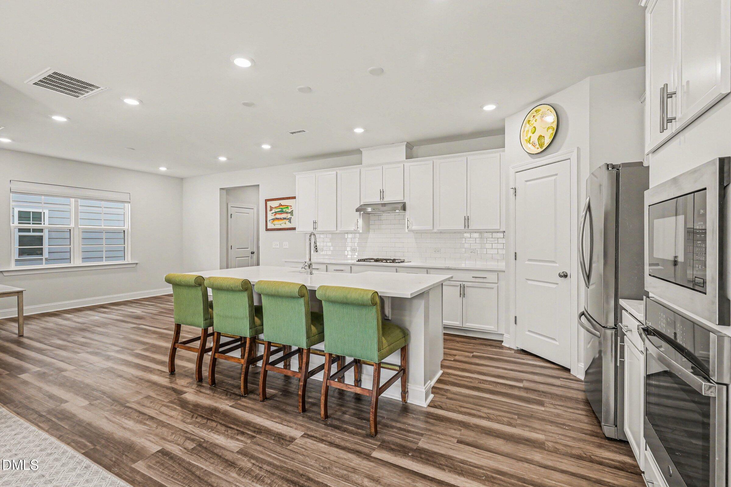 4921 Abundance Avenue Raleigh, NC 27616 - Photo 11 of 36 a kitchen with stainless steel appliances granite countertop a dining table chairs and granite counter tops