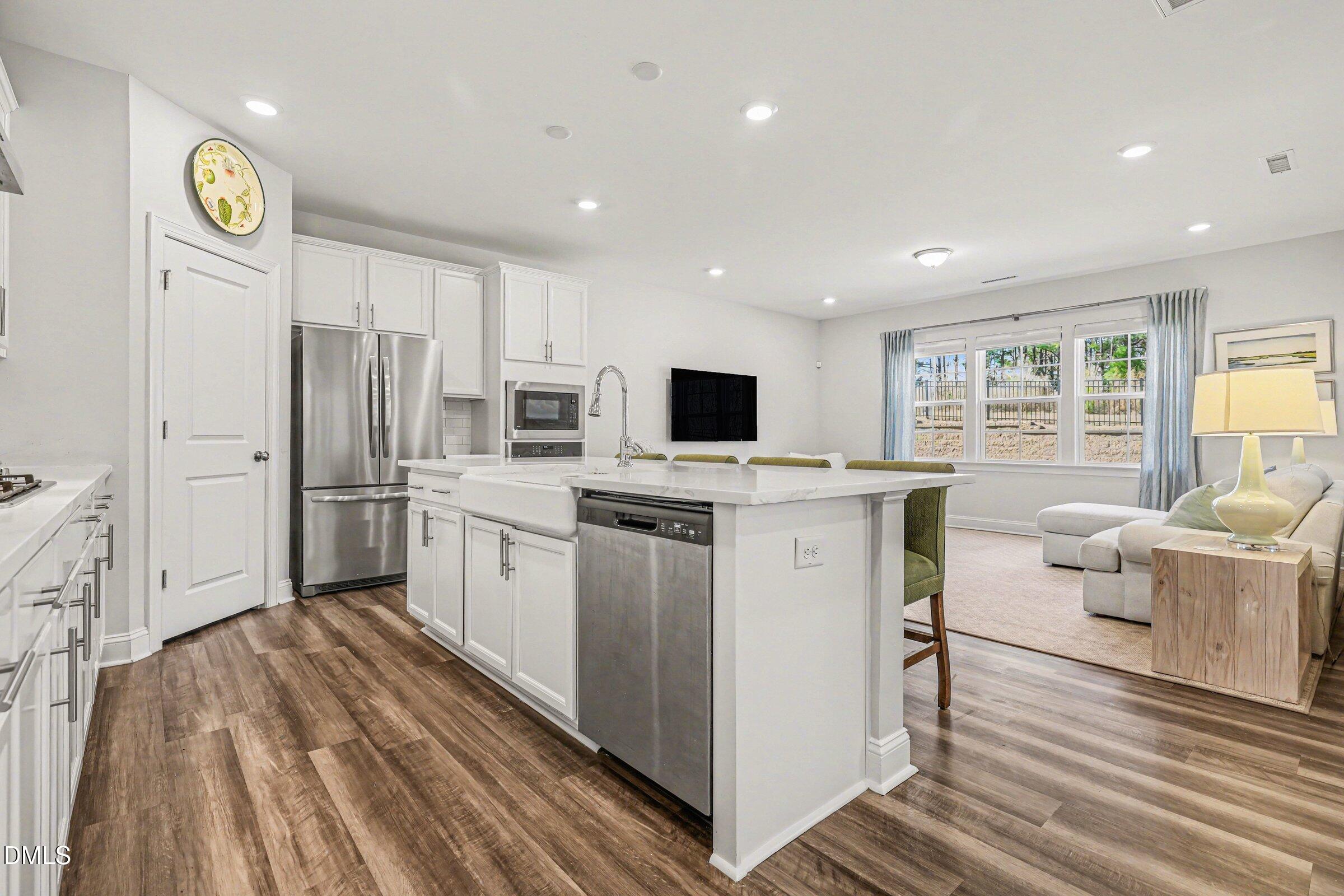 4921 Abundance Avenue Raleigh, NC 27616 - Photo 16 of 36 a kitchen with white cabinets and stainless steel appliances