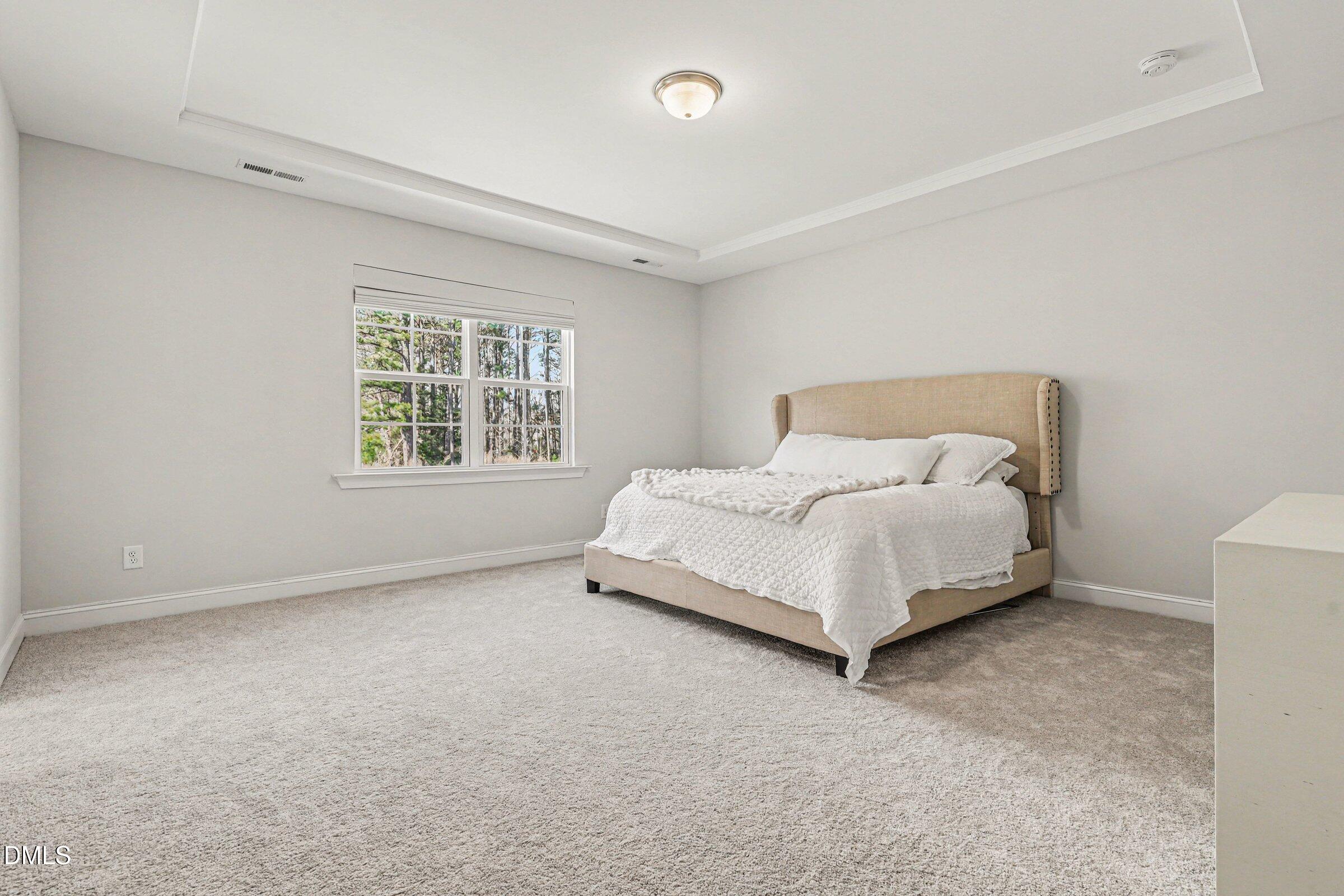 4921 Abundance Avenue Raleigh, NC 27616 - Photo 21 of 36 a bed sitting in a bedroom next to a window