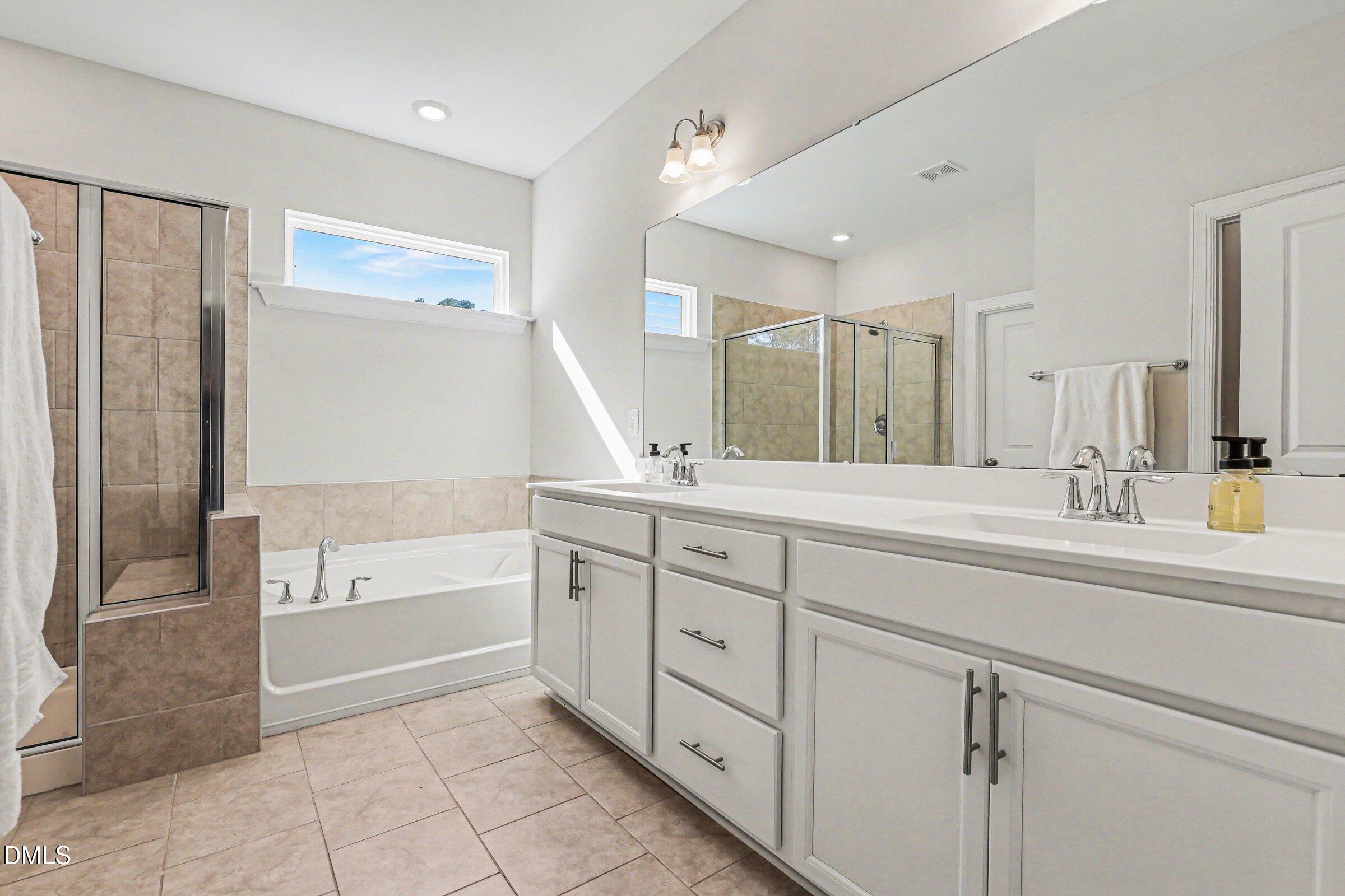 4921 Abundance Avenue Raleigh, NC 27616 - Photo 23 of 36 a spacious bathroom with a tub sink and mirror