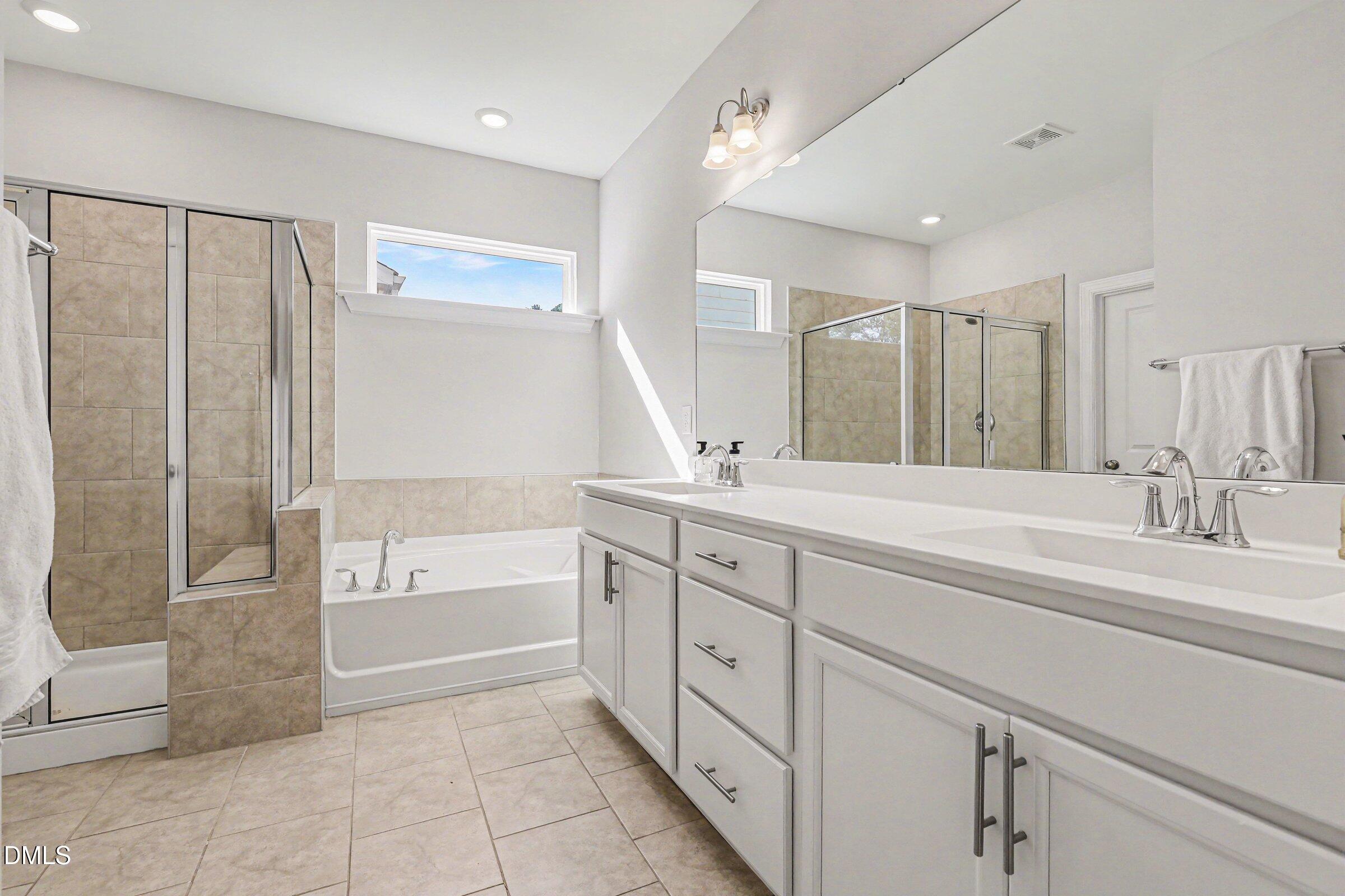 4921 Abundance Avenue Raleigh, NC 27616 - Photo 24 of 36 a spacious bathroom with a shower sink and mirror