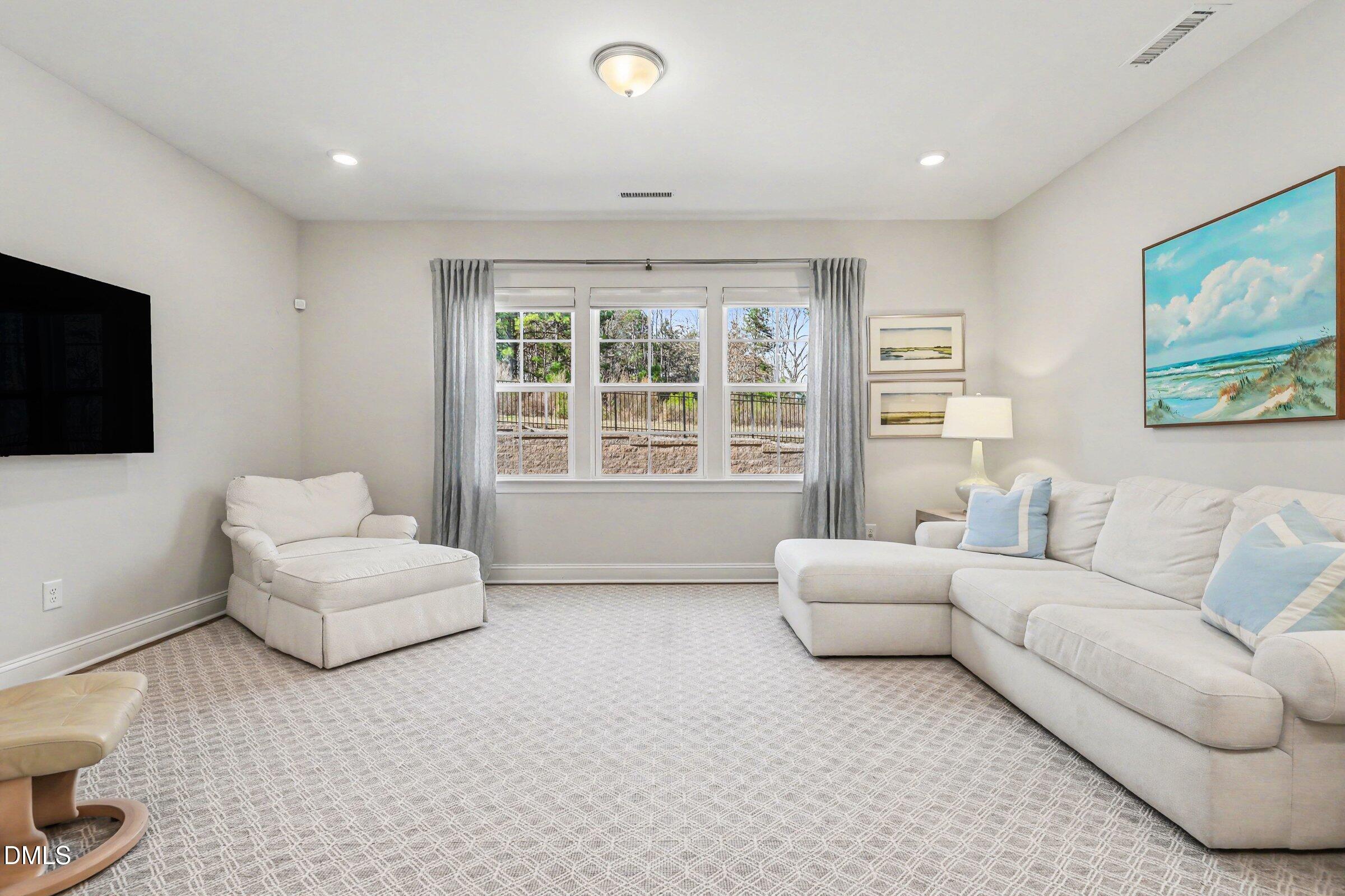 4921 Abundance Avenue Raleigh, NC 27616 - Photo 6 of 36 a living room with furniture a flat screen tv and a large window