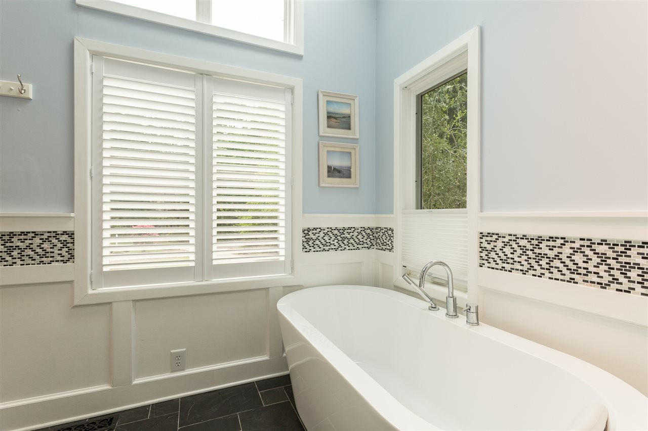 4409 Wood Valley Drive Raleigh, NC 27613 - Photo 19 of 30 Soak your cares away in the updated footed soaking tub that is bathed in natural light in a private setting. Plantation shutters provide privacy and the soaring window above provides light. Footed Soaking Tub