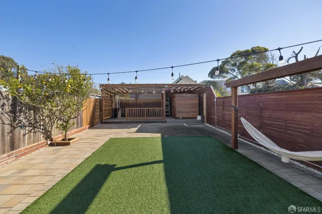 a backyard of a house with table and chairs