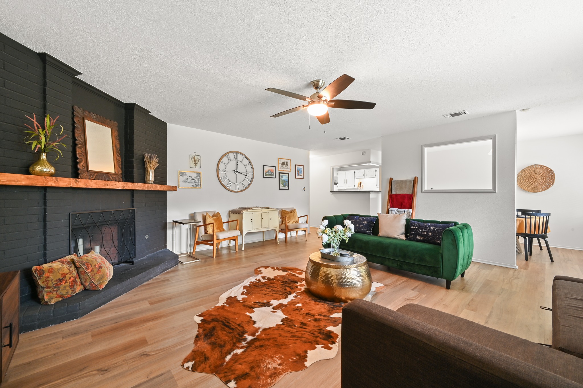 6805 Rearden Road Austin, TX 78745 - Photo 5 of 26 A well-lit living area showcases a captivating fireplace and durable hardwood flooring.