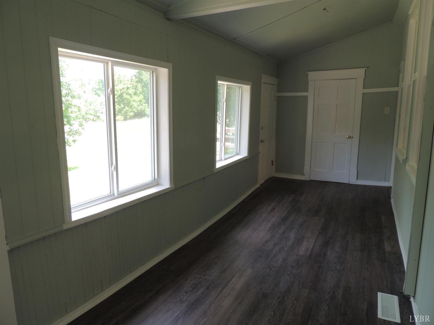 7007 Wards Road Rustburg, VA 24588 - Photo 19 of 26 a view of an empty room with wooden floor and a window