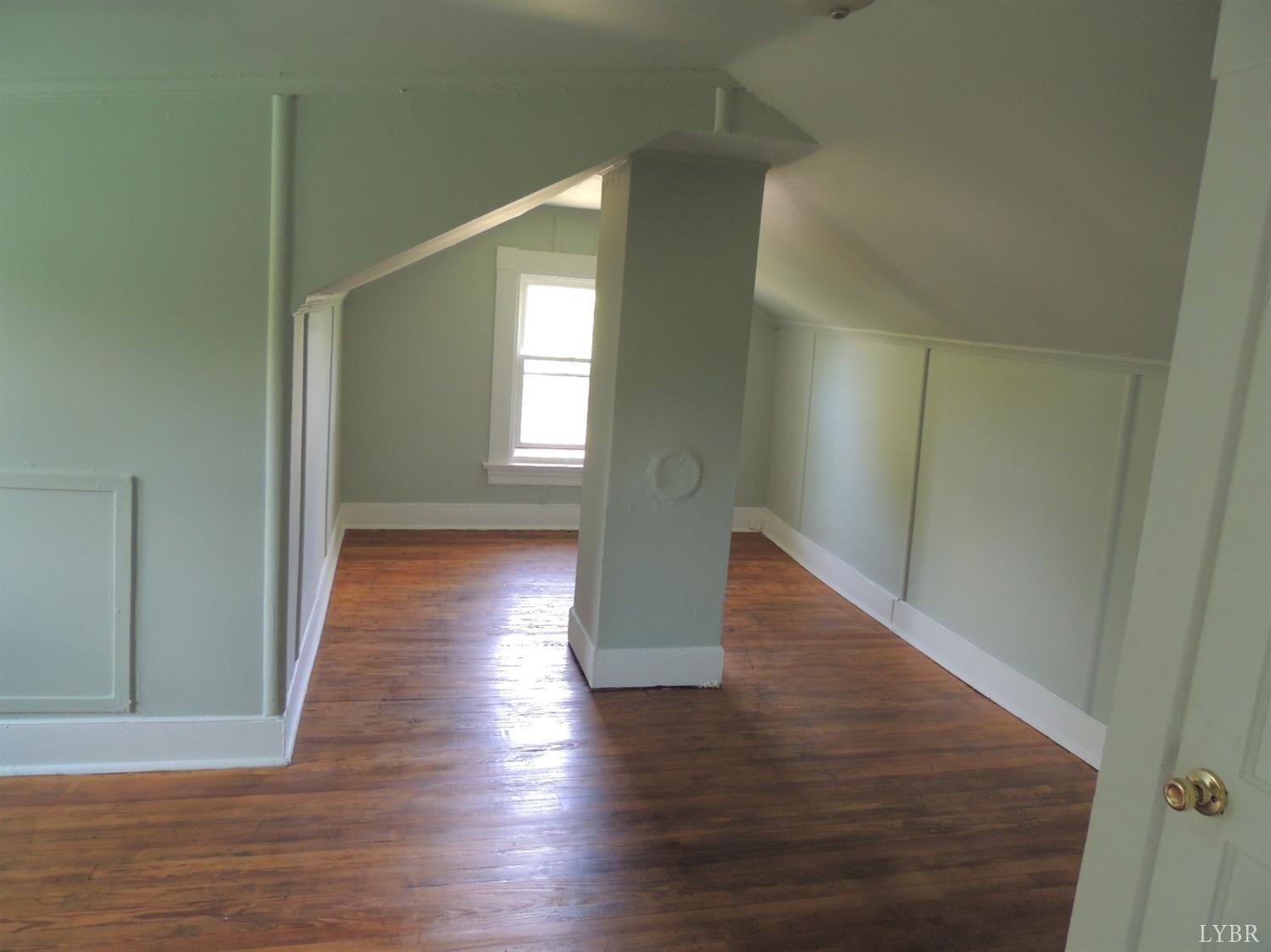 7007 Wards Road Rustburg, VA 24588 - Photo 23 of 26 a view of an empty room with wooden floor and a window