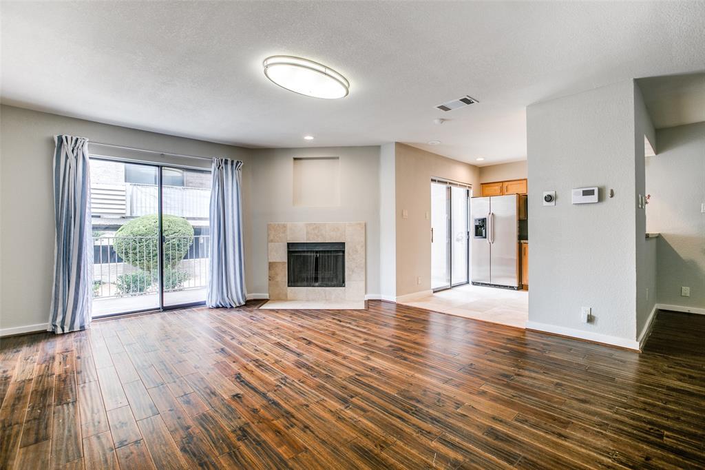 a view of empty room with wooden floor and fireplace