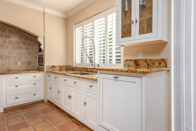 a bathroom with a granite countertop sink and a window