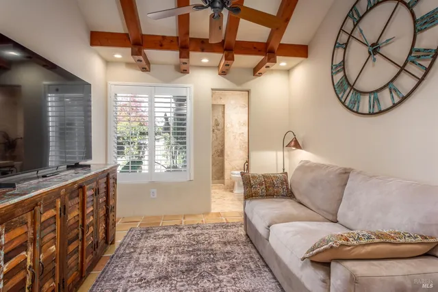 a living room with furniture a flat screen tv and a window