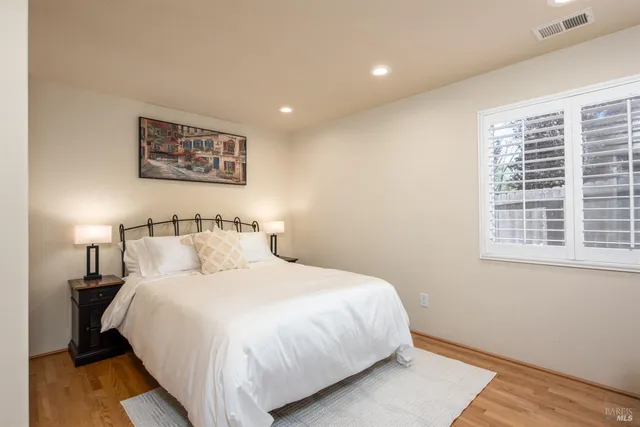 a large bed sitting in a bedroom next to a window
