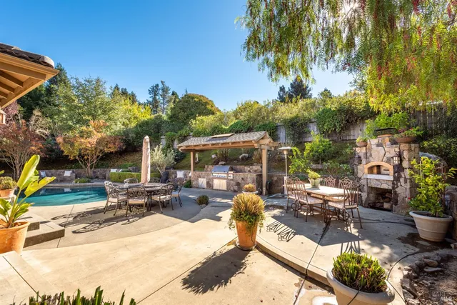 a view of a patio with couches and table and chairs under an umbrella